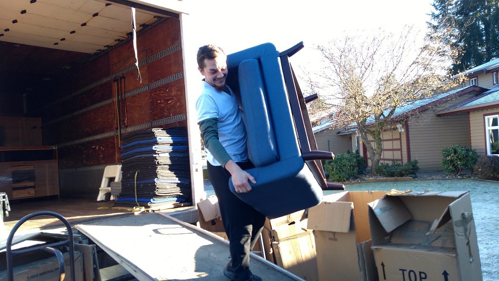 Burnaby Movers Signature Moving carrying a chair 778-325-6683